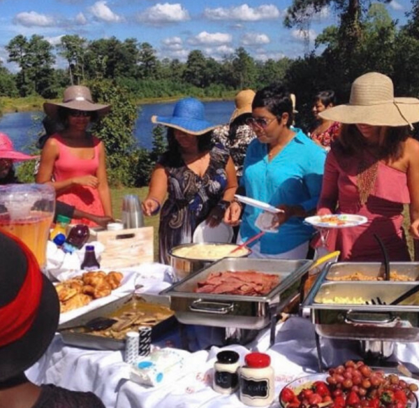 Outdoor brunch buffet with people in hats.